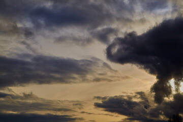 Obraz premium Layered clouds in the sky form voluminous shapes, creating a dramatic effect. Sunlight gently diffuses across their surface, adding shades of blue and gray.