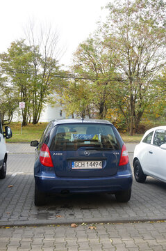 Vertical shot of a parked dark blue Mercedes Benz A180 CDI on the street in Poznan, Poland