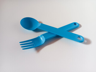 Fototapeta premium Close up of blue plastic spoon and fork isolated on white background.