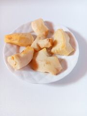 Close up of fresh peeled and cut ginger in a plate isolated on white background.