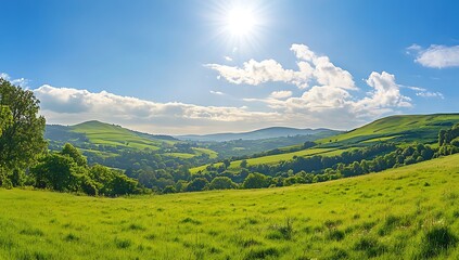Naklejka premium Vast Green Expanse A panoramic view of a lush green landscape with rolling hills and a bright blue sky dotted with fluffy white clouds creating a sense of peace and tranquility