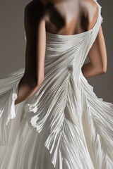 A stunning close-up of a draped white dress showcasing intricate pleats and graceful design elements.