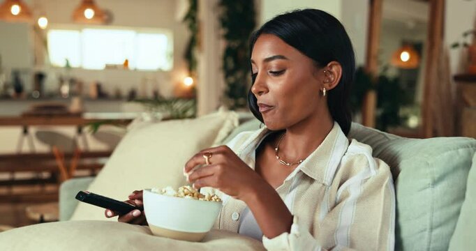 Eating popcorn, watching tv and woman relax in home with streaming service, movie subscription or show. Food, television or girl with remote in living room for film, entertainment or chill with snack