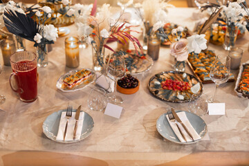 stylish decorated banquet table in restaurant with food and drinks
