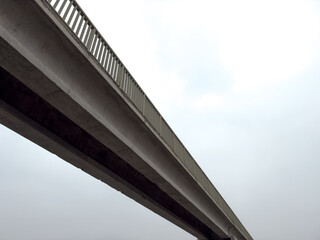 Long concrete bridge against dark sky