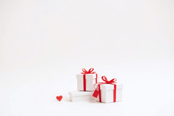 two white gift boxes red ribbons bows red heart gift tag white bg
