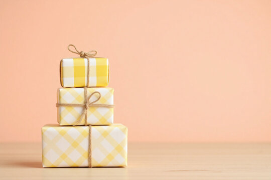 three stacked gift boxes yellow white checkered twine peach bg