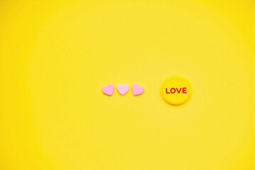 three heart shaped objects yellow background LOVE circle