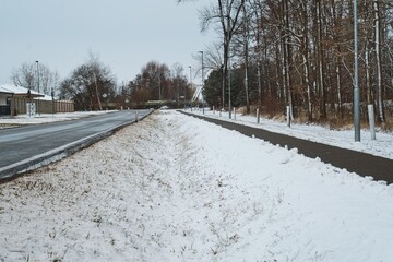 Obraz premium Snowy Urban Pathway and Roadside: Nature vs. Urban Contrast