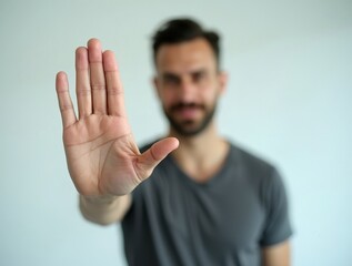 Man making stop gesture with hand in bright studio setting