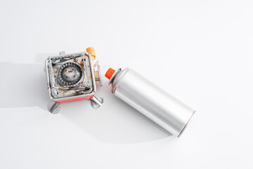 Portable gas stove for camping with a cylinder on a white background. Replaceable gas cylinder and...
