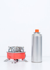 Portable gas stove for camping with a cylinder on a white background. Replaceable gas cylinder and...