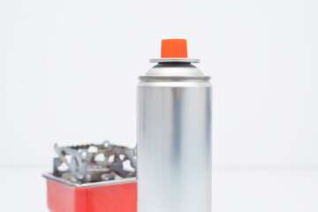 Portable gas stove for camping with a cylinder on a white background. Replaceable gas cylinder and...