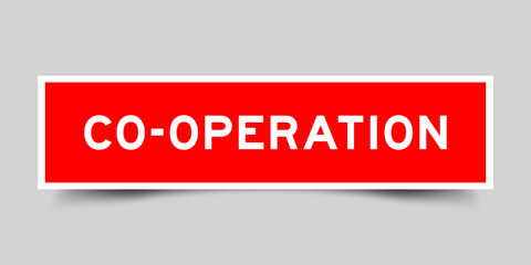 Red color square shape sticker label with word co operation on gray background