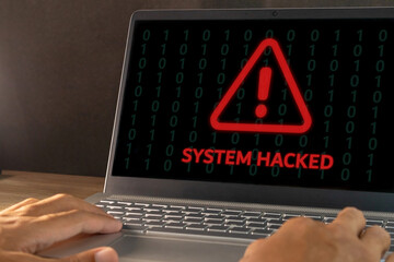 Warning of a system hacked concept. Hacker or cyber criminal with laptop stealing user personal data.