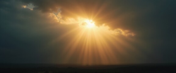 Fototapeta premium Dramatic sunlight breaking through dark clouds in a moody landscape