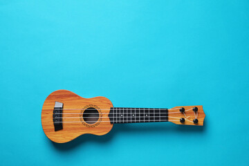 Obraz premium One ukulele on light blue background, top view. Space for text