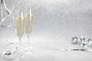 Champagne in glasses and decor on silver background. Space for text