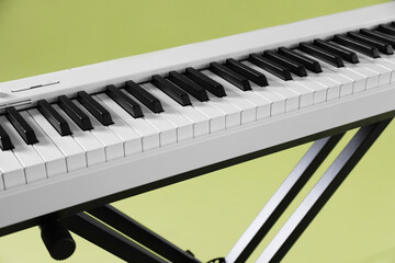 Synthesizer on green background, closeup. Electronic musical instrument