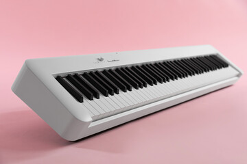 Synthesizer on pink background, closeup. Electronic musical instrument