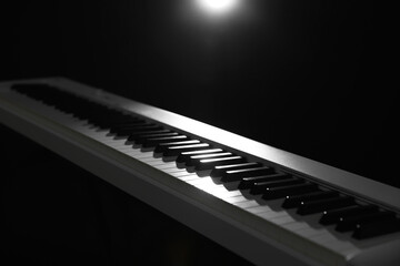 Synthesizer on black background, closeup. Electronic musical instrument