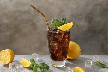 Fresh iced cola with mint and lemons on grey table