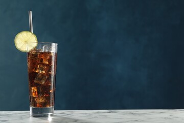 Refreshing iced cola with lime slice on white marble table against blue background. Space for text