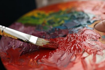 Painting with palette and paintbrush, closeup view