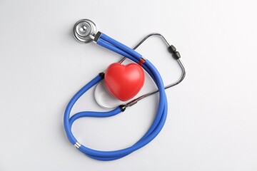 Cardiology. Stethoscope and red decorative heart on white background, flat lay