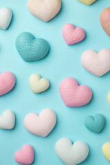 Obraz premium Colorful tiny hearts on pastel blue background. Minimal concept idea. Top view.
