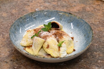 traditional european sweet dish varieniki pastries with blueberries, sweet lunch served food on a plate in a restaurant
