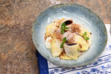 traditional european sweet dish varieniki pastries with blueberries, sweet lunch served food on a plate in a restaurant