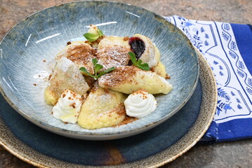 traditional european sweet dish varieniki pastries with blueberries, sweet lunch served food on a plate in a restaurant