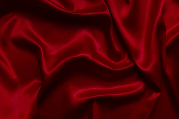 The top view of the red satin surface looks luxurious and beautiful. with sparkling waves Abstract background design copy space Card or banner (blurred or blurry)