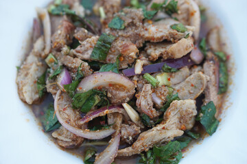 Spicy grilled pork salad  mix with chili lemon onion and herb vegetable on white plate. Concept, delicious food menu. Popular Thai food, tasty appetizer for serving with beer   
