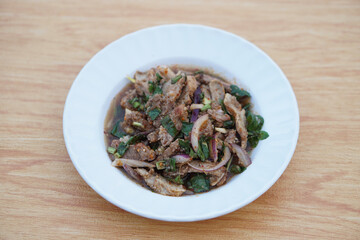 Spicy grilled pork salad  mix with chili lemon onion and herb vegetable on white plate. Concept, delicious food menu. Popular Thai food, tasty appetizer for serving with beer.           