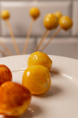 Coconut balls coated in glass icing sugar on a white plate, traditional Brazilian Bala Baiana dessert.