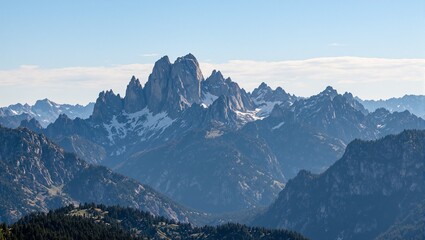 Majestic mountain peaks at sunrise with dramatic ridges and valleys highlighted by gentle morning sunlight