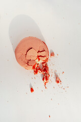 Broken pink macaroon cookie on white background