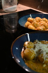 close up view of food background, potato gnocchi with pepper cream sauce, grated parmesan cheese and herbs, close up view of served food