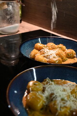 close up view of food background, potato gnocchi with pepper cream sauce, grated parmesan cheese and herbs, close up view of served food