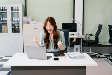 Asian business woman are delighted and happy with the work they do on their tablet, laptop and taking notes