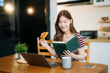 oung Asian woman with sitting working on laptops and tablets in a cozy workspace. Perfect for education, innovation,