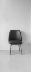 minimalist modern chair,  black leather upholstery and light wooden legs, combines comfort and aesthetics. The clean lines and reflection of the polished floor make it a great addition modern interior