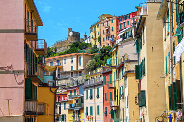 A view of a typical Italian street with castle on the hill in a resort town Riomaggiore (Cinque Terre, Ligurie, Italia).