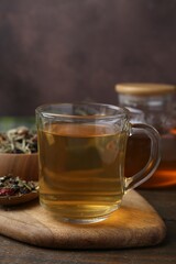 Delicious herbal tea and dry leaves on wooden table