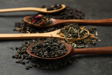 Different types of tea brew on black table, closeup