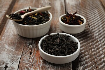 Different types of tea brew on wooden table, closeup
