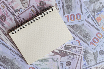 Notebook on US dollar banknotes, symbolizing financial planning, budgeting, investment strategies, business accounting, money management, and economic development.