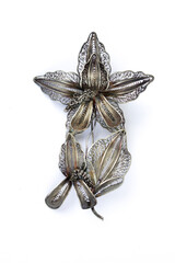 A silver flower-shaped brooch isolated on white background